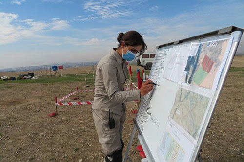 Noor, Team Leader of a clearance team, updates the board with the key information on the current task Noor, Team Leader of a clearance team, updates the board with the key information on the current task