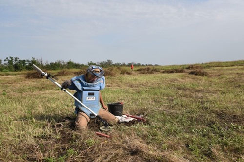 Ukrainian deminer marking an area after getting a sound with the detector.