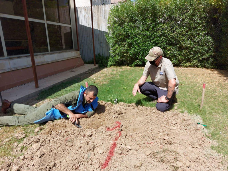 An FSD technical expert guides a trainee deminer during an exercise to excavate an improvised mine (Erbil, May 2021)