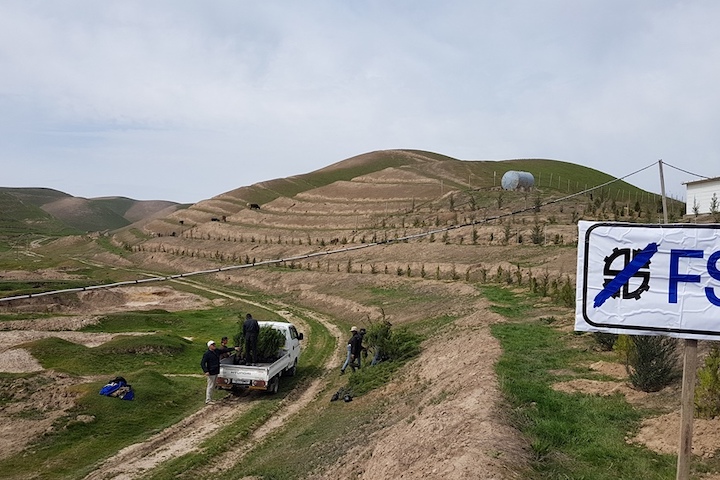 View of the area after planting and second mini truck unloading trees in Tajikistan