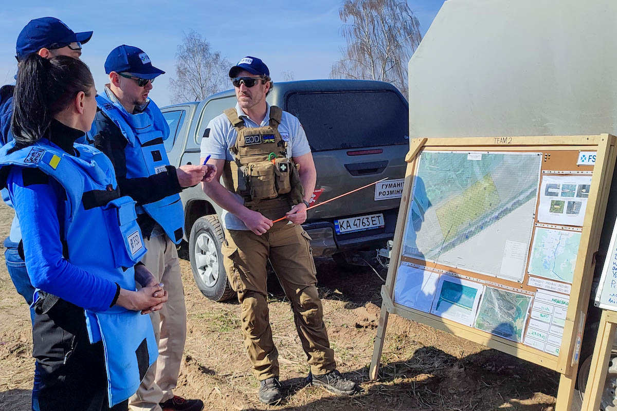 Morning brief of a demining team before clearance can begin in a field in Chernihiv oblast, Ukraine