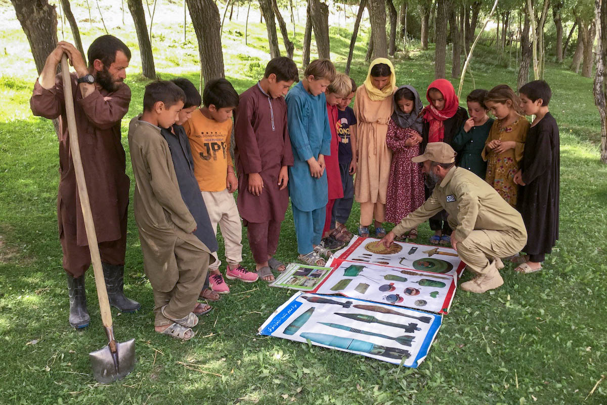 FSD team members explaining the dangers of explosives and good behaviour to children and farmers in Bagh-i-Tal village, Afghanistan.