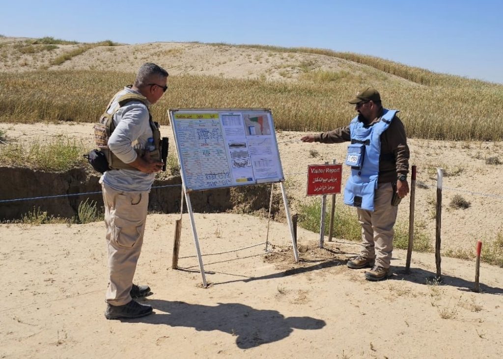 FSD Operator conducting metal detector clearance procedures with Khalidiya village in the background iraq